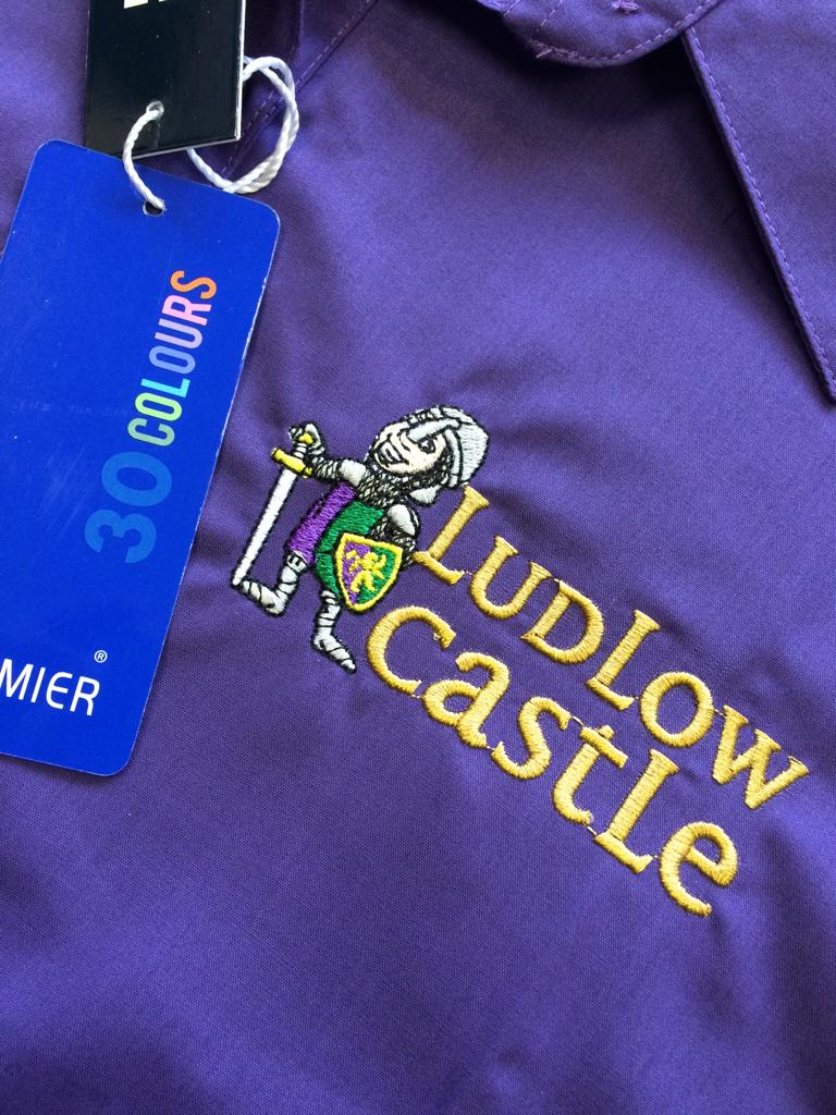 Detailed embroidered crest on a purple garment